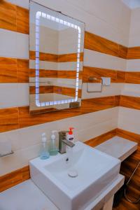 a bathroom with a white sink and a mirror at Coral Beach Hotel in Mirissa