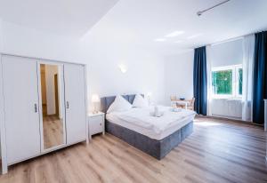 a bedroom with a large bed and a mirror at Hotel Bergheim in Bergheim