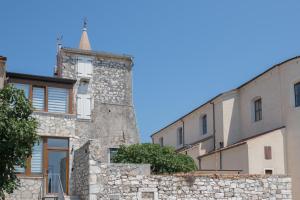 un antiguo edificio de piedra con una torreta al lado de dos edificios en Luxury Villa Christian, en Umag