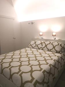 a bedroom with a large bed with two lamps on it at Casetta Verga Loft in Catania