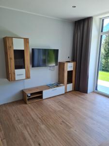 sala de estar con TV de pantalla plana en la pared en Ferienapartments Bensch - Haus Reiskofel en Reisach