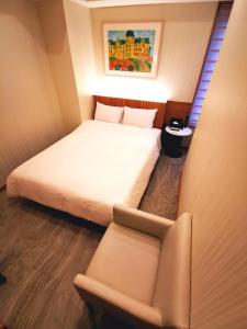 1 dormitorio pequeño con 1 cama y 1 silla en HOTEL MOND Omiya - Vacation STAY 85327v en Saitama