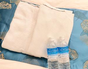 two bottles of water sitting on top of a pillow at HOTEL MOND Omiya - Vacation STAY 85327v in Saitama