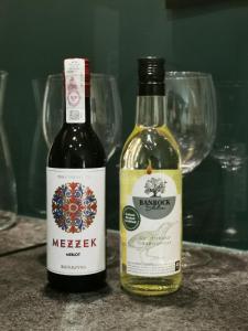 Duas garrafas de vinho numa mesa com copos de vinho em Leśny Apartament Nad Zalewem No. 2 em Kielce