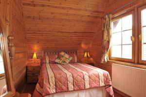 a bedroom with a bed in a log cabin at Ardlui Lochside Lodges in Ardlui