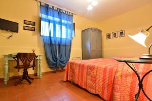 1 dormitorio con cama, mesa y ventana en Agriturismo La Dimora dei Cavalieri, en Vaglio di Basilicata