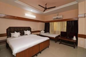 een slaapkamer met een bed, een stoel en een raam bij Hotel Natraj in Bilāspur