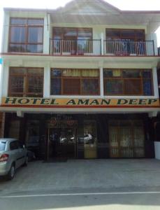 un cartel de escritura de hotel amman en la parte delantera de un edificio en Hotel Amandeep en Dharamshala