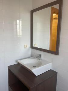 ein Badezimmer mit einem weißen Waschbecken und einem Spiegel in der Unterkunft Vera Pueblo Salinas in Vera