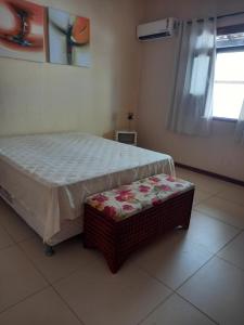 a bedroom with a bed and a bench in it at Uma Casa para o Descanso! in Camaçari