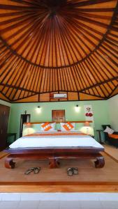 a bedroom with a large bed with a large roof at Angel Island Eco Resort in Labuan Bajo