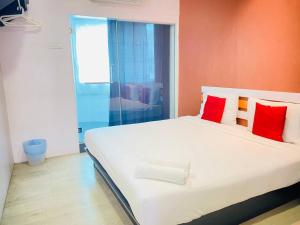 a bedroom with a large white bed with red pillows at Orange Hotel Segamat in Segamat