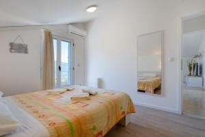 ein weißes Schlafzimmer mit einem Bett mit Handtüchern darauf in der Unterkunft Apartments Mili in Ston