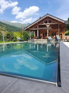 a swimming pool in front of a house at Chalet savoyard d'exception avec piscine chauffée in Bourg-Saint-Maurice