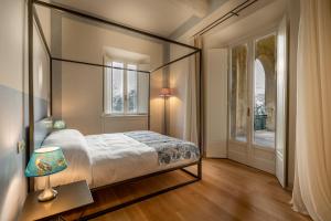 a bedroom with a canopy bed and a window at Il Casale Denari - Tenuta duca Denari in Santa Maria della Versa