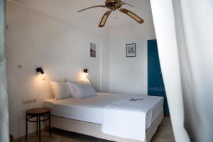 una camera bianca con letto e ventilatore a soffitto di Villa Flisvos a Marathias