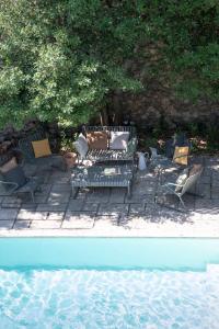 una panchina e sedie accanto a una piscina d'acqua di Maison Sumiane a Brignoles