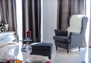 a living room with a chair and a stool at Apartments Villa Capitano in Mlini