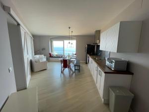 a kitchen and living room with a view of the ocean at Cap Sa Sal - Sa Roca 3 in Begur