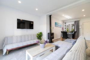 a living room with two couches and a tv at Chalet Árbol de la Vida in Chiclana de la Frontera