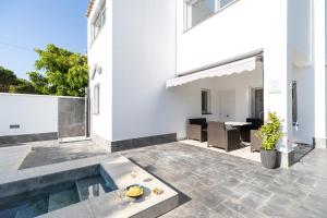 une terrasse d'une maison avec une piscine dans l'établissement Chalet Árbol de la Vida, à Chiclana de la Frontera