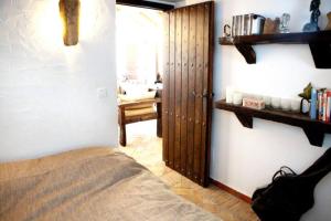 1 dormitorio con puerta a una habitación con cama en El vergel encantado en La Ñora