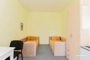 a room with two beds and a table and a desk at MiegOK777 in Palanga