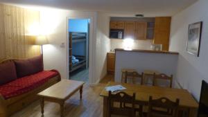 a living room with a couch and a table and a kitchen at Grand studio 6 pers. Super Besse, Résidence *** in Besse-et-Saint-Anastaise