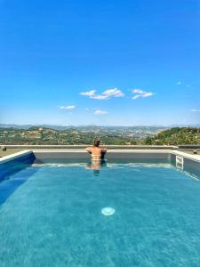 un uomo seduto in una piscina con vista di Hotel Perusia a Perugia