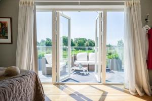 Schlafzimmer mit einer Glasschiebetür, die auf eine Terrasse führt in der Unterkunft Villa Lysholmen in Särö