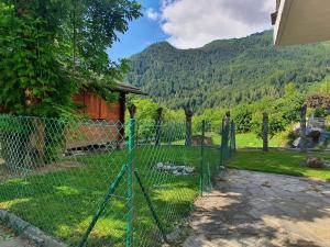 a fence in front of a house with a mountain at Chalet Charme Ovronnaz in Ovronnaz