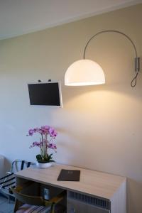 a room with a desk with a lamp and flowers at Hotel Fabricia in Portoferraio