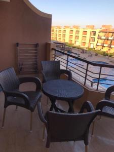 a group of chairs and tables on a balcony at Cozy Chalet in El Ain El Sokhna شالية بالعين السخنة in Ain Sokhna +22 photos
