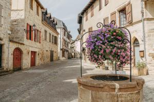 an empty street with a basket of flowers in an alley at Village Vacances La Riviera Limousine by Popinns in Altillac