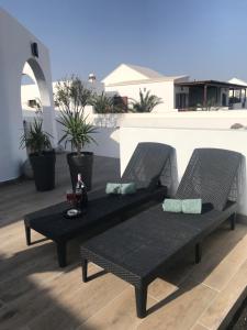 a patio with two wicker chairs and a table at Casa Dylan in Puerto Calero