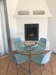a glass table and chairs in a room with a fireplace at Casa Dylan in Puerto Calero