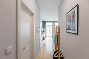 korytarz z białymi ścianami i drewnianą podłogą w obiekcie Turquoise Central Flat w AC & Balcony by LovelyStay w Porto
