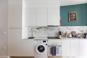 biała kuchnia z pralką w obiekcie Turquoise Central Flat w AC & Balcony by LovelyStay w Porto