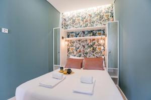 małą sypialnię z łóżkiem z ręcznikami w obiekcie Turquoise Central Flat w AC & Balcony by LovelyStay w Porto