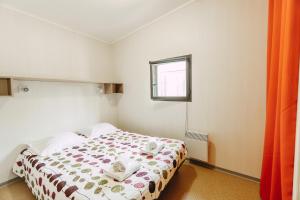 a bedroom with a bed and a window at Village Vacances La Riviera Limousine by Popinns in Altillac