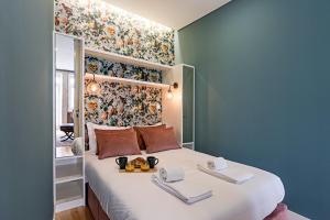 sypialnia z dużym białym łóżkiem i kwiatową ścianą w obiekcie Turquoise Central Flat w AC & Balcony by LovelyStay w Porto