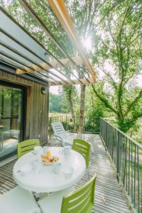 Altillac的住宿－波平斯豪華河濱度假村，露台配有白色的桌子和椅子,
