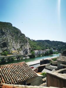 uma vista para um rio com edifícios e uma montanha em Le monde de Théodore em Anduze