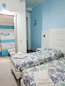 a room with two beds and a mirror at Melody Rooms in Soverato Marina
