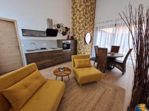 ein Wohnzimmer mit einem gelben Sofa und einem Tisch in der Unterkunft Gite cosy dans une demeure de charme - Laura in Thuir + 15 Fotos