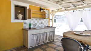 a kitchen with a sink and a table at Les Maisons La Mansardina by Rentbeat in Sannicola