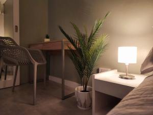 a room with a table and a potted plant and a lamp at The Beach Life Pereybere in Pereybere