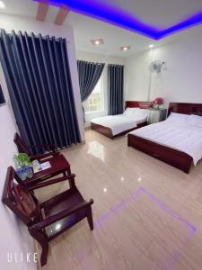 a large bedroom with two beds and a chair at Hotel Phương Anh in Phù Cát