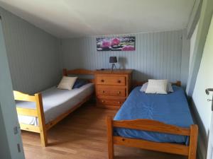 a bedroom with two beds and a dresser at Les Arums de Fondeminjean in Vertheuil-en-Médoc