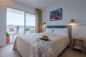 a bedroom with a bed and a large window at Áncora Salou La Siesta Apartments in Salou